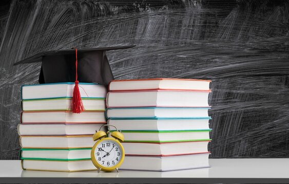 Graduation cap with on wooden desk in classroom