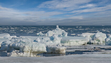 Russia. The western coast of Sakhalin Island. Picturesque ice floes of the spring Pacific Ocean.