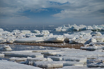 Russia. The western coast of Sakhalin Island. Picturesque ice floes of the spring Pacific Ocean.