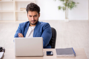 Fototapeta premium Young male employee working in the office