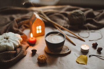cozy winter still life with a cup, candles, plaid. Hygge home decor. 