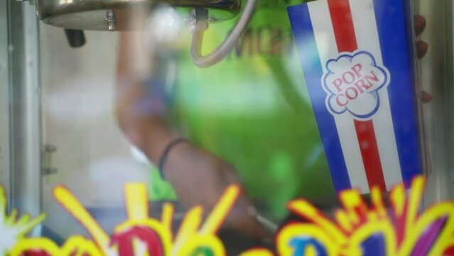 Man serving popcorn to a little girl at a fair stall