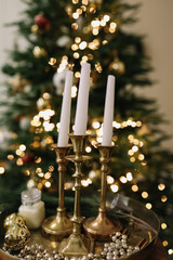 Christmas candles and ornaments over dark background with lights