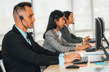 Fototapeta na wymiar Business people wearing headset working in office to support remote customer or colleague. Call center, telemarketing, customer support agent provide service on telephone video conference call. Jivy