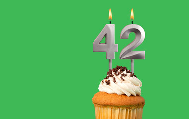 Birthday card with candle number 42 - Cupcake on green background