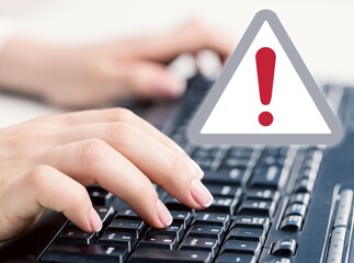 Businesswoman work on laptop with warning exclamation sign