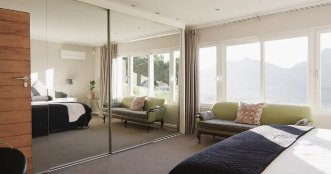 Sunny bedroom home interior with mirrored built in wardrobe, copy space