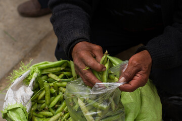 Photo of hands filling peas in a bag at a local market in Peru.
