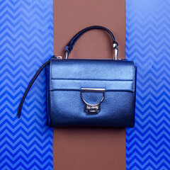 Trendy metallic blue leather women's handbag with silver metal clasp, top handle, and zipper...