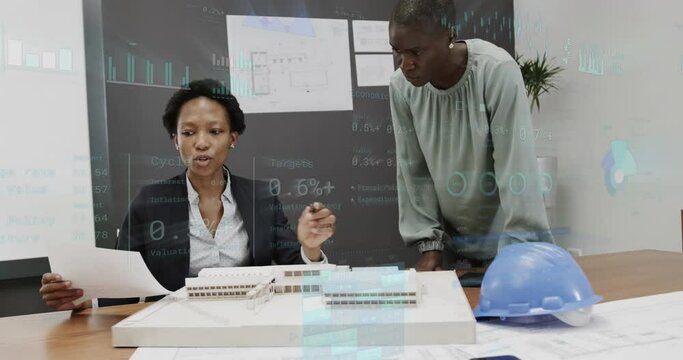 Animation of graphs and changing numbers, diverse female architects discussing 3d model of building