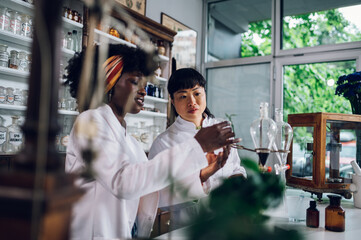 Interracial pharmacists are working on a cure discovery in a vintage pharmacy.