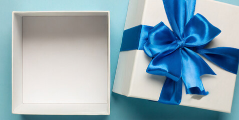 blank open white gift box with cyan blue bottom inside or top view of opened present box wit
