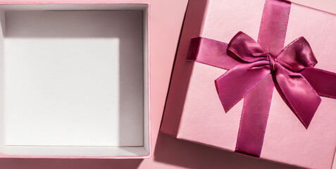 blank pink pastel color present box or open gift box with pink ribbon and bow isolated on pi