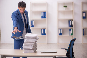 Young male employee unhappy with excessive work in the office