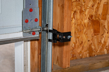 Overhead garage door opener safety sensor installed on roller track. Home safety, repair and...