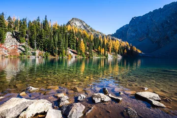 Schilderijen op glas Picturesque view on Blue Lake. Autumn mountains landscape with Blue Lake and bright orange larches in the North Cascades National Park in Washington State, USA. © Victoria Nefedova