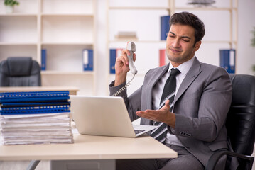 Naklejka premium Young male employee working in the office