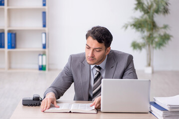 Naklejka premium Young male employee working in the office