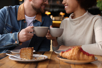 International relationships. Lovely couple having romantic date in cafe, closeup