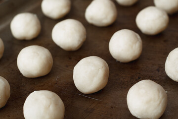 Fototapeta na wymiar Ready to bake vanilla cookie dough balls on rustic baking sheet