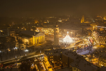 Fototapeta na wymiar Beautiful aerial view of decorated and illuminated Christmas tree on the Cathedral Square at night in Vilnius. Celebrating Christmas and New Year in Lithuania.