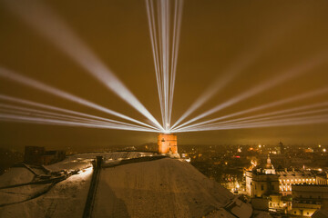 Scenic aerial view of Gediminas tower in Vilnius Old Town beautifully illuminated for 700th birthday celebration. Main symbol of Lithuanian capital at night.