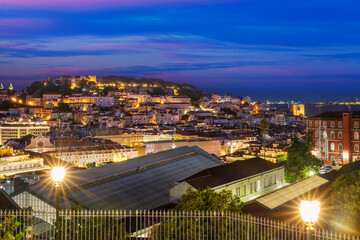 Obraz premium View of Lisbon famous view from Miradouro de Sao Pedro de Alcantara tourist viewpoint in the evening. Lisbon, Portugal. Camera pan