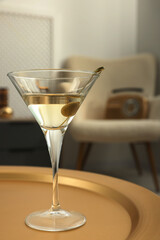 Martini cocktail with olive on table in room. Relax at home
