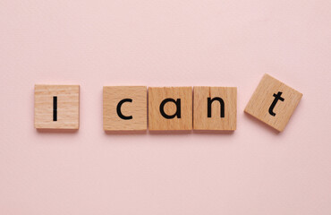 Motivation concept. Changing phrase from I Can't into I Can by removing square with letter T on pink background, top view