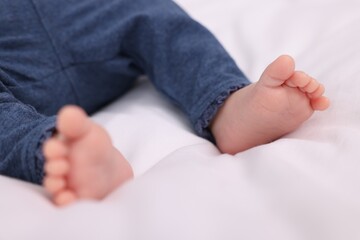 Newborn baby lying on white blanket, closeup