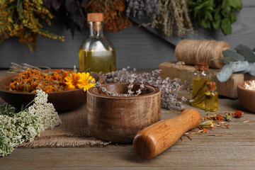 Mortar with pestle and dry lavender flowers on wooden table. Medicinal herbs