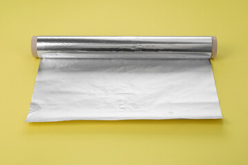 Roll of aluminum foil on yellow background