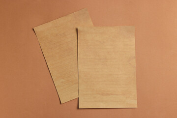 Sheets of old parchment paper on brown background, flat lay