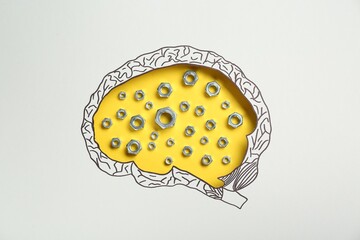 Analytical thinking. Nuts on yellow background, top view through paper with brain shaped hole and...