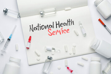 National health service (NHS). Notebook with text and medications on white background, flat lay