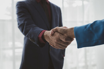Two businessmen shake hands after a joint meeting, business venture handshake saluting, business...