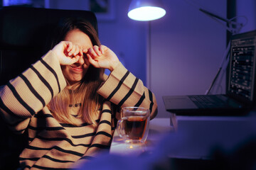Woman Working Late Rubbing her Eyes Feeling Tired. Person suffering from computer vision syndrome...
