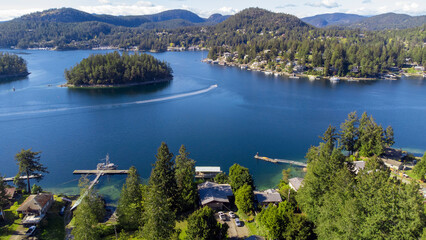 A single boat whips round a small island in Garden Bay, Sunshine Coast