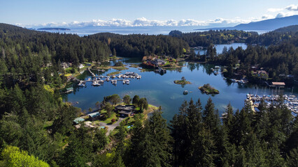 Panoramic view of Maderia Park, sunshine Coast. Shallow water covers the bay and forest trees the coastline. Boats and homes look out onto the bay. In the distance a line of clouds 