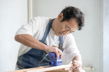 サンダーをかける男性 お家でDIY 趣味の時間