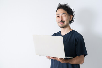 Smiling man looking at camera with laptop Image of bodyworker, nurse, doctor