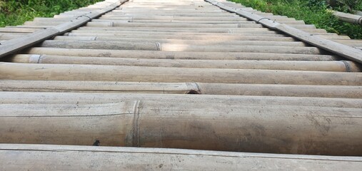 Fototapeta premium Wooden bamboo bridge pathway over the ponds