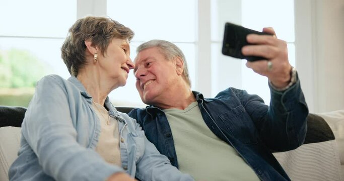 Happy senior couple, selfie and sofa with kiss, care and bonding in retirement with post on web blog. Elderly man, woman and photography for memory, profile picture or hug for romance on social media
