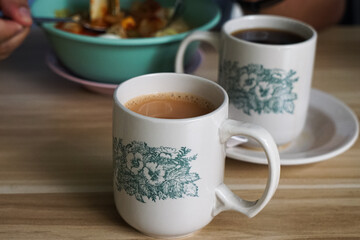 Popular drink in Malaysia called Teh Tarik. It is a sweet drink made from tea with milk. Fractal on the cup is generic print.