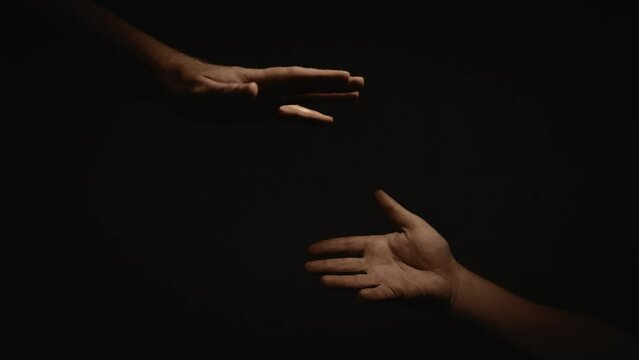two hands reaching out to each other on a dark background, cinematic lighting  4K 24 fps