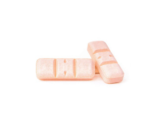 Isolated pills with half and third marks. Rectangular pink tablets. Prescription medicine for cat or dog anxiety. Drug, supplement or painkiller background. White background. Selective focus.