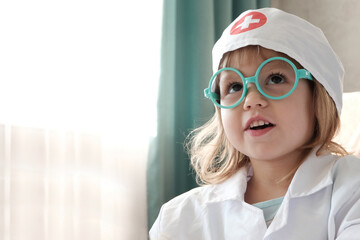 A little girl with fair hair and black eyes, three years old, in medical clothes, glasses, close-up...