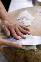 chef cutting fish in a kitchen at vertical composition