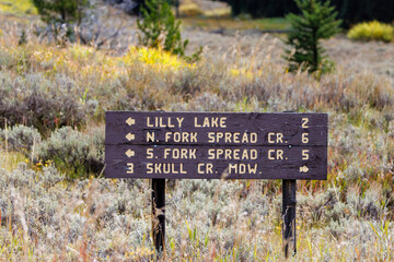Sign indicating distance and directions of Lilly Lake, North Fork Spread Creek, South Fork Spread  Creek and Skull Creek Meadow in Bridger Teton National Forest in western Wyoming during early fall