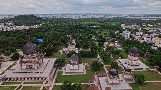 Qutub Shahi Tombs, hyderabad, telangana with crowded buildings and clouds at the background aerial drone shot